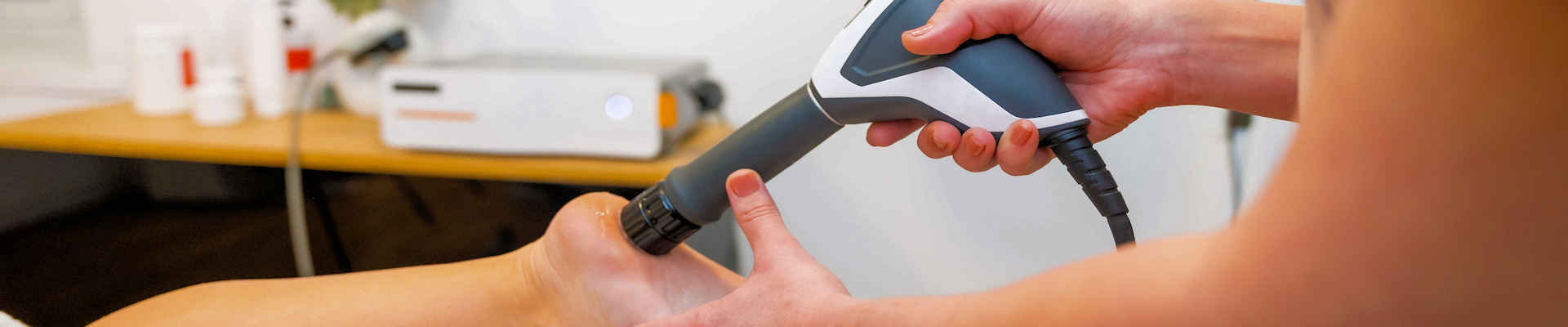Shockwave therapy gun on heel of foot
